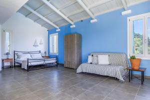罗查基恩Villa Pasifika的卧室拥有蓝色的墙壁,配有一张床和一张沙发