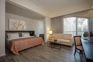 耶路撒冷耶路撒冷丹能酒店的一间卧室配有一张床、一张沙发和一张桌子