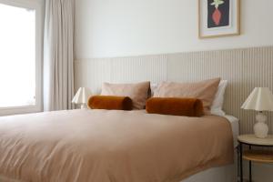 Shoalhaven HeadsThe Heads House的一间卧室配有一张带两盏灯的大型白色床。