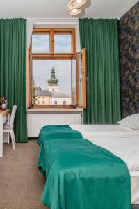 克罗斯诺The Old Townhouse的一间卧室配有一张带绿色窗帘的床和窗户。