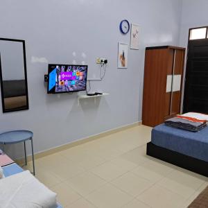 瓜拉丁加奴Avohomestay YouTube Netflix的一间设有床铺和墙上电视的房间