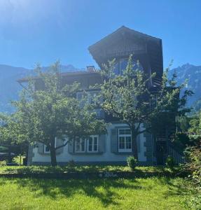 伯尼根Chalet Mignon - your vacation oasis at Lake Brienz的前面有两棵树的白色房子