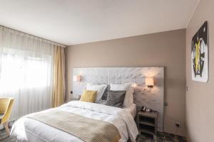 安锡安纳西南部美居酒店的一间卧室设有一张大床和一个窗户。