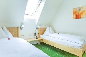 沃尔特湖畔佩莎赫Ferienhaus Kleine Gartenvilla的配有白色床单的客房内的两张床