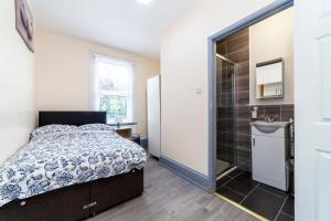 依尔福Highlands Gardens Suites的一间卧室配有一张床、淋浴和盥洗盆