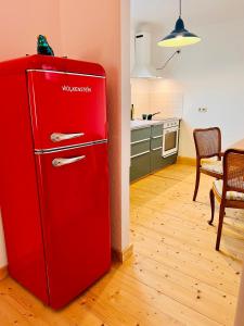 哥达Kuschelige helle Ferienwohnung的带桌子的厨房里的红色冰箱