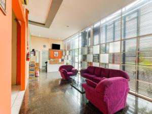 三宝垄SPOT ON 2451 Camel Residence的客厅配有两把紫色椅子和窗户