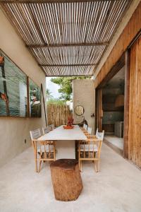 卡拉伊瓦Pousada Zinga Caraíva的庭院设有一张桌子和椅子,配有木制天花板