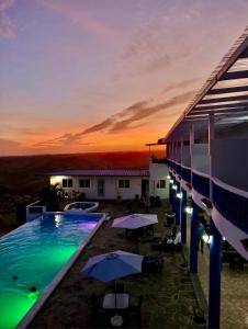 普拉亚科罗纳多Hotel Eclipse, Playa Coronado的日落时分带游泳池和遮阳伞的度假村