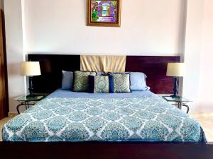普拉亚科罗纳多Hotel Eclipse, Playa Coronado的一间卧室配有一张带蓝色和白色棉被的床