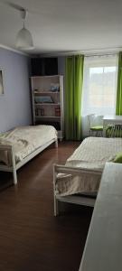 Ludwikowice KłodzkieAgroturystyka Przystanek Góry Sowie的一间卧室设有两张床,窗户设有绿色窗帘