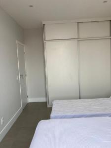 里约热内卢Apartamento reformado, tudo novo, Copa-Ipanema的一间白色卧室,配有两张床和一个衣柜