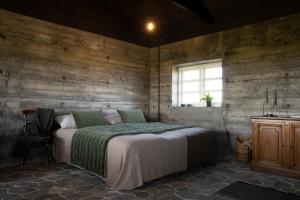 霍尔斯沃德吕尔Jakob´s old farmhouse的卧室配有一张床铺,位于带木墙的房间内