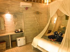 蓝梦岛The Lucky Cottage的木墙客房设有一间带天蓬床的卧室