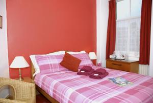 温德米尔亚当广场宾馆的一间卧室配有一张带紫色铺面毯子的床