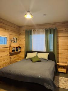 TeijoKiiski Home的一间卧室配有一张带木墙的大床
