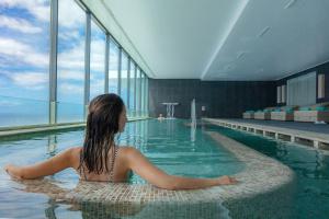 丰沙尔VidaMar Resort Hotel Madeira - Dine Around Half Board的女人坐在游泳池里
