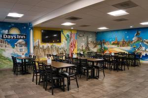 亚历山德里亚Days Inn by Wyndham WestEnd Alexandria,VA Washington DC Area的用餐室配有桌椅和壁画