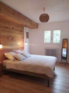 加普La marMotte perchée的一间卧室设有一张带木墙的大床