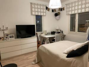 坦佩雷Modern 6-bedroom villa near Tampere city的一间卧室配有一张床和一张书桌及电视