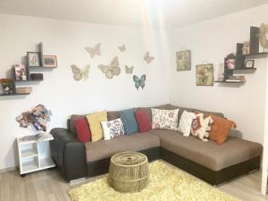 布拉索夫Sweet Butterflies Residence的客厅配有沙发和蝴蝶壁