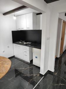 贝尔格莱德Fenix 1的白色的厨房配有水槽和桌子