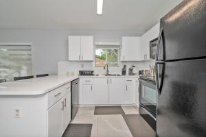 迈阿密花园Hard Rock Hidden Gem!的厨房配有白色橱柜和黑色冰箱。