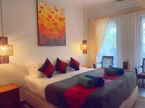 库塔Villa Cantik Kuta Regency的一间卧室配有一张大床和枕头