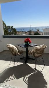 美洲海滩Boutique studio, sea views of Las Vistas and free wifi的阳台上的桌子、两把椅子和花瓶