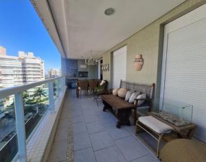 圣劳伦斯海滨Riviera São Lourenço Excelente Apartamento e Local的大楼内的阳台配有沙发和椅子