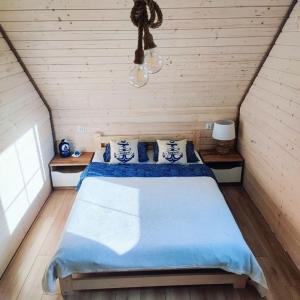 加茨比亚格拉Domki Halo Morze的一间卧室配有一张大床,提供蓝色的床单和枕头