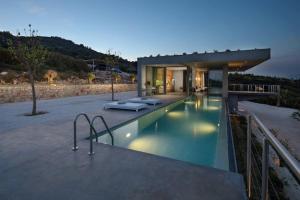 KoríthionStunning 180° Sea View Designer Villa for two的一座房子前面设有游泳池