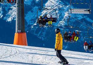 Sankt Peter am KammersbergFEWO Gabi Haus Pacher的滑雪缆车前的滑雪板上的人