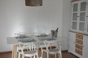 布雷根茨RELAX Apartment mit Garten - Lifestyle am Bodensee, Fahrräder inklusive的白色的厨房配有白色的桌子和椅子