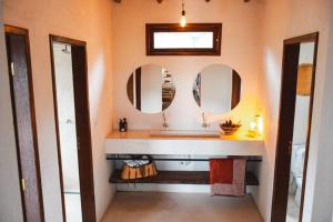 伦索伊斯Casa AMAR Piscinas Naturais的一间带水槽和两面镜子的浴室