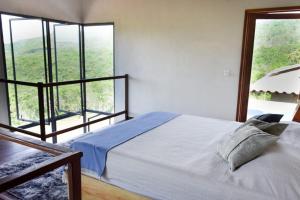 伦索伊斯Casa AMAR Piscinas Naturais的一间卧室设有一张床和一个大窗户