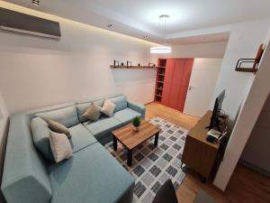 GjakoveRita Apartment的客厅配有蓝色的沙发和电视