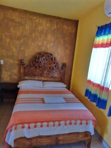 AquismónHOTEL ESTRELLA HUASTECA的卧室内的一张床位,配有木制床头板