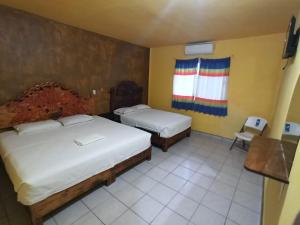 AquismónHOTEL ESTRELLA HUASTECA的酒店客房设有两张床和窗户。