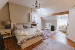 里彭HIGH SAINT COTTAGE - Stunning 3 Bed Accommodation located in Ripon, North Yorkshire的一间卧室配有一张大床和一个吊灯。