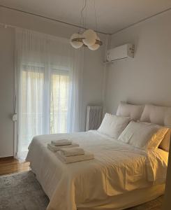 雅典Alex’s home next to Laiko的卧室配有白色床和毛巾
