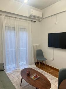 雅典Alex’s home next to Laiko的客厅配有电视、沙发和桌子