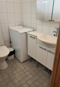 阿卡斯洛姆波罗Mäntymajat的白色的浴室设有卫生间和水槽。