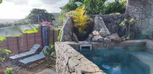 Case-PiloteSunset Sapphire的一个带岩石墙的游泳池和一个游泳池