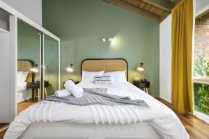 墨尔本Carlton Dream: Leafy 2bed 2bath Lygon Str Townhouse的一张白色大床,位于带绿色墙壁的房间