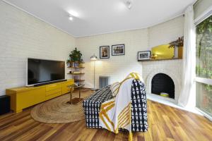 墨尔本Carlton Dream: Leafy 2bed 2bath Lygon Str Townhouse的一间带电视和壁炉的客厅