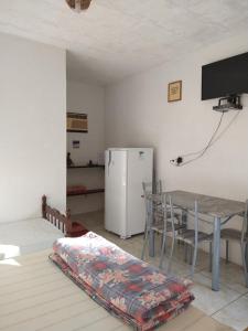 特林达德Araribé Pousada的客厅配有桌子和冰箱
