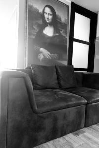 罗马Gioconda’s Apartment的客厅里的一张黑色沙发,上面有一张女人的照片