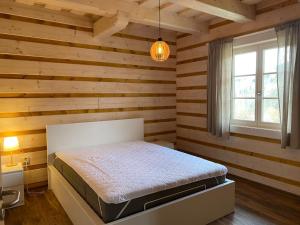 多尔尼莫拉瓦Roubenka ARCHA的卧室配有一张床铺,位于带木墙的房间内