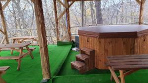 VăraticiBrancoveanu Glamping的木制冰屋,带长凳和绿色地板